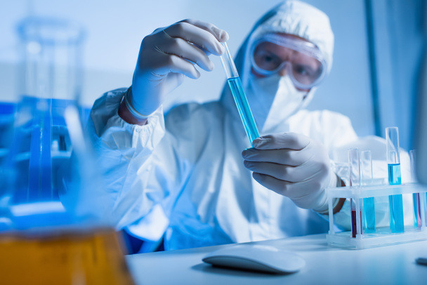 stock-photo-blurred-scientist-hazmat-suit-holding-test-tube-chemical-laboratory